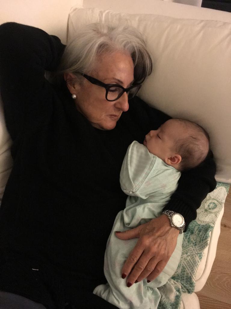 Nanna tenderly holding a sleeping newborn